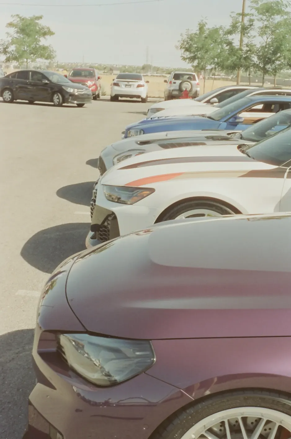 A close view along a row of parked cars at a JDC meet